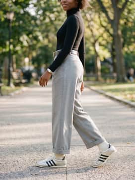 Opt for light grey wide-leg trousers, a tucked-in black turtleneck bodysuit, and a structured silver belt to create a futuristic, high-fashion ensemble perfect for a gallery visit.