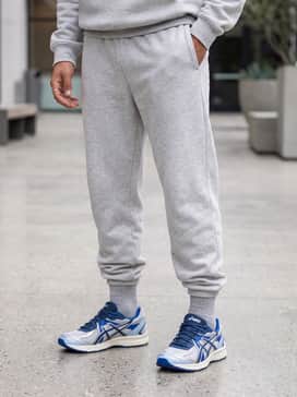 Light-grey oversized fleece joggers and a matching cropped hoodie for a cohesive and comfortable travel-ready outfit.