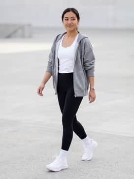 Jolt 5 – High-waisted black compression leggings paired with a white performance tank top and a grey oversized zip-up hoodie for a classic gym-to-brunch aesthetic.