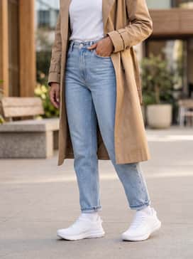 Jolt 5 – Light-wash straight-leg denim jeans with a tucked-in minimalist graphic tee and a tan trench coat for a sophisticated yet comfortable city look.