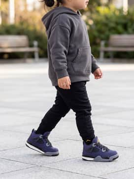 Jordan 4 Retro Imperial Purple – An oversized charcoal grey hoodie paired with black slim-fit joggers and a matching purple beanie for a classic streetwear vibe.