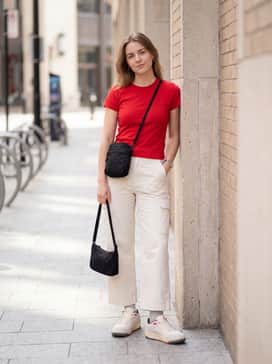Beige wide-leg cargo pants matched with a fitted baby tee in a vibrant red shade to pull out the sneaker's accent colors, finished with a small black nylon shoulder bag.
