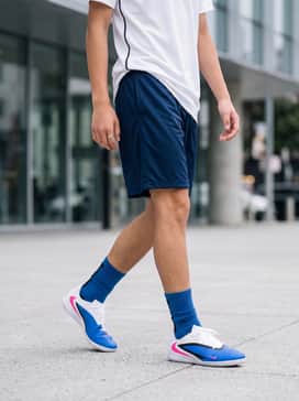 A full soccer training kit featuring navy blue mesh shorts, a white moisture-wicking jersey, and blue crew-length athletic socks.