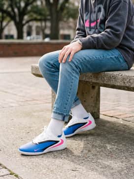 A trendy streetwear look with slim-fit light wash denim jeans and an oversized graphic hoodie that features a pop of neon color.