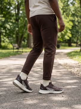 Juniper Trail 3 – Dark wash tapered athletic jeans, a simple white crewneck tee, and an unbuttoned flannel shirt in a brown and orange plaid pattern that complements the shoe's earthy tones for a casual weekend vibe.