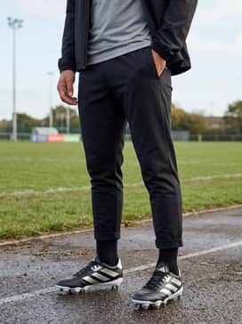 A training-ready ensemble with black tapered joggers, a breathable tech t-shirt, and a lightweight, water-resistant windbreaker for outdoor practice sessions.