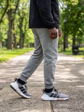 Wear them with heather grey tech fleece pants and a black windbreaker jacket to lean into the sporty, functional vibes of the speckled midsole design.