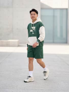 Kd18 – Forest green mesh basketball shorts, a cream oversized graphic hoodie, and white crew socks for a courtside-ready aesthetic.