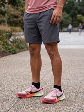 Style with charcoal grey technical hiking shorts and a breathable rose-toned performance tee for a coordinated, functional outdoor outfit.