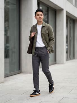 Slim-fit raw indigo denim jeans, a white heavyweight tee, and an unbuttoned olive utility shirt for a rugged yet clean look.