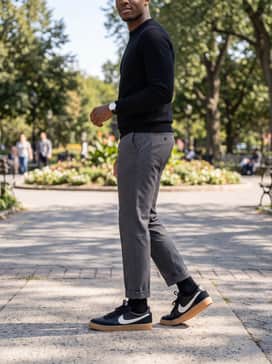 Cuffed charcoal chinos, a black turtleneck sweater, and a minimalist silver watch for a sophisticated monochromatic ensemble.