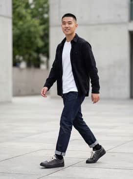 Killshot 2 – Dark wash slim-fit denim jeans rolled at the cuff, paired with a crisp white crewneck t-shirt and an unbuttoned black flannel shirt for a classic Americana look.