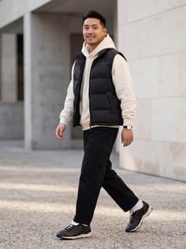 King Indoor Icons Mens Sneakers – A pair of relaxed-fit black cargo pants tucked slightly at the ankle, paired with an oversized cream-colored hoodie and a black puffer vest to echo the shoe's contrast stitching.