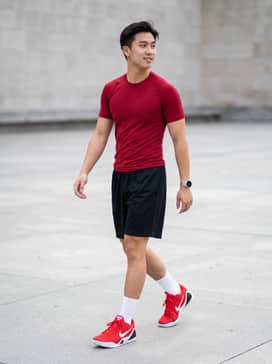 A full-court look featuring black mesh basketball shorts, a crimson moisture-wicking compression shirt, and white mid-calf athletic socks to highlight the shoe's low profile.