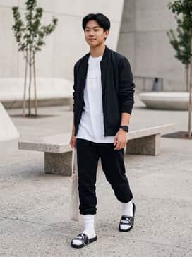 A pair of tapered black joggers, a crisp white oversized graphic tee, and high-quality white crew socks for a quintessential streetwear aesthetic.