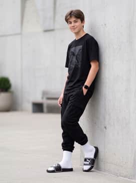 Leadcat 20 Slides – Trend-forward streetwear ensemble with white crew-length athletic socks, oversized black cargo pants, and a boxy graphic t-shirt.