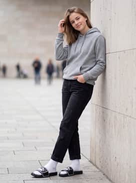 Combine with relaxed black denim jeans and an oversized neutral-toned hoodie, finishing the look with crisp white crew socks for a trendy streetwear vibe.