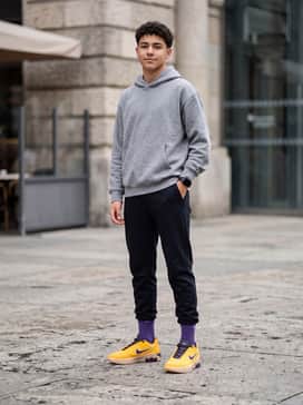 Black tapered tech joggers worn with a slightly oversized grey heathered hoodie for a modern, functional athleisure look.
