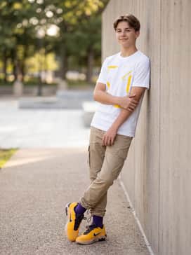 Khaki cargo pants with adjustable bungee hems styled with a crisp white graphic tee that features yellow accents to tie the outfit together.