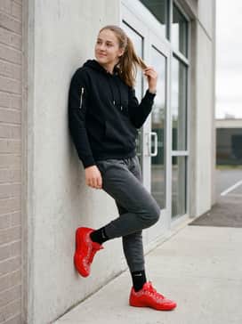 Lebron Xxiii Best In Class – A relaxed warm-up outfit pairing tapered charcoal grey joggers with a black pullover hoodie featuring gold metallic accents that complement the shoe's hardware.