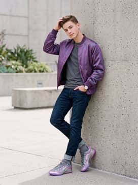 An off-court casual look pairing slim-fit dark-wash denim with a crisp white graphic tee and a purple satin bomber jacket that pulls from the shoe's iridescent piping.