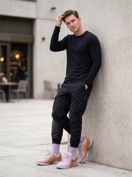 Black techwear cargo pants with functional straps and a sleek black performance long-sleeve tee to let the metallic copper pop as the focal point.