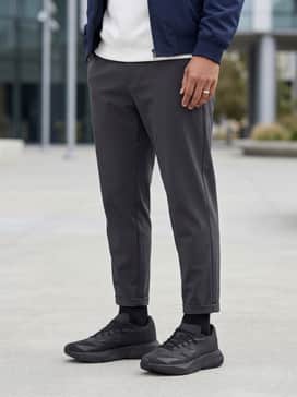 Dark charcoal tapered chinos with a crisp white crewneck sweatshirt and a navy Harrington jacket for a clean, smart-casual weekend vibe.