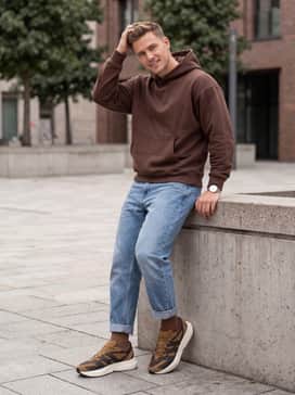 Relaxed-fit light wash denim jeans with a chocolate brown oversized hoodie to complement the sneaker's earthy color palette.