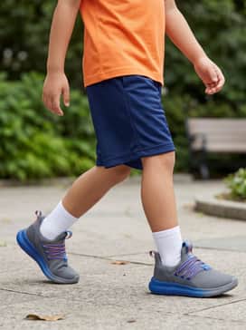 A pair of navy blue mesh athletic shorts paired with a moisture-wicking bright orange t-shirt and white crew socks for a full sport-ready look.