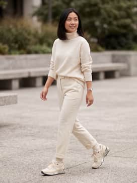 High-waisted cream wool trousers paired with a matching oversized cashmere turtleneck for a sophisticated, monochromatic tonal look.
