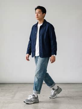 A pair of vintage-wash relaxed fit jeans, a white heavyweight cotton t-shirt, and a navy blue worker jacket for a timeless Americana aesthetic.