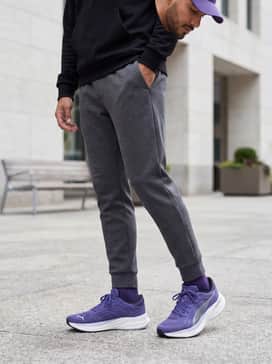 Magnify Nitro 2 – A streetwear-inspired ensemble with tapered charcoal joggers, an oversized black graphic hoodie, and a purple baseball cap to coordinate with the shoe's primary color.