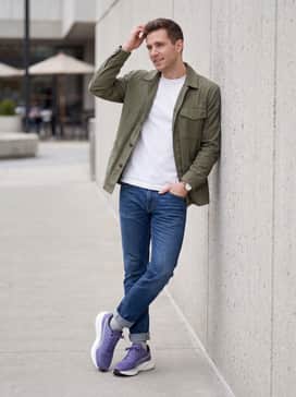Magnify Nitro 2 – A clean, casual outfit pairing slim-fit indigo cuffed jeans with a heavyweight white t-shirt and an unbuttoned olive green utility jacket for weekend errands.