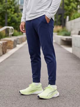 Tapered navy blue tech-fleece joggers combined with a light grey quarter-zip running pullover for cooler morning sessions.