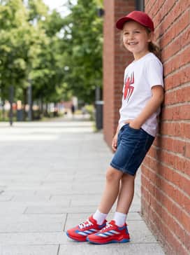Marvel Spiderman Adizero Impact Turf Kids Shoes – Classic blue denim shorts worn with a Spider-Man graphic tee and a red baseball cap for a fun, themed weekend outing.