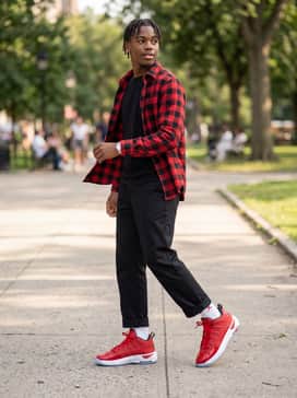 Max Aura 7 – Relaxed-fit black chinos paired with a red-and-black checkered flannel shirt layered over a simple black tank top for a cohesive color story that isn't overwhelming.