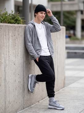 Max Aura 7 – A relaxed casual ensemble with slim-fit light-wash denim jeans, a grey heathered crewneck sweatshirt, and a simple silver chain for a subtle metallic touch.
