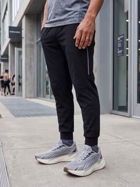 Maxima Pro Mens Sneakers – Gym Ready: Tapered black joggers with reflective side detailing, paired with a fitted navy performance hoodie and moisture-wicking quarter-length athletic socks.