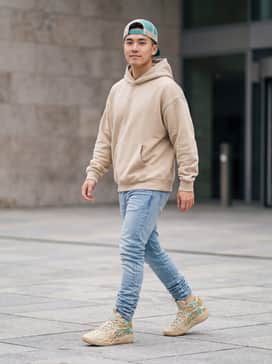 Mb04 Flare – Light-wash stacked denim jeans paired with an oversized sand-colored hoodie and a teal-accented trucker hat to mirror the shoe's color palette.