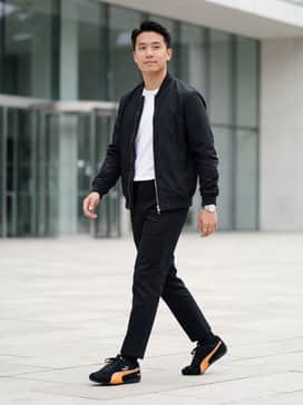 Mclaren Racing Speedcat Mens Sneakers – Slim-fit black denim paired with a clean white crew-neck t-shirt and a lightweight black bomber jacket to create a sharp monochromatic base that highlights the vibrant orange detailing.