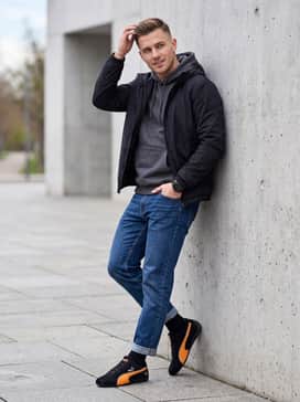 Mclaren Racing Speedcat Mens Sneakers – Straight-leg indigo jeans worn with a heather grey hoodie and a technical black windbreaker for a layered, casual weekend ensemble suitable for city exploration.