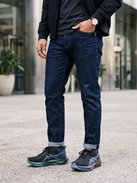 Slim-fit dark indigo denim jeans, a white heavyweight cotton tee, and a black bomber jacket to balance the shoe's sporty silhouette with classic streetwear.