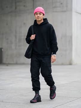 A pair of black relaxed-fit cargo pants with cinchable cuffs to highlight the chunky midsole, paired with a heavyweight oversized black hoodie and a neon pink beanie to echo the shoe's accents.