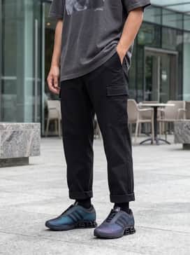 A casual Y2K-inspired outfit with light-wash relaxed-fit denim, an oversized graphic t-shirt in a charcoal grey, and a metallic silver crossbody bag.