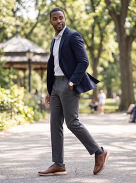 Charcoal grey dress slacks and a light-patterned button-up shirt, finished with a navy blazer for a versatile office-to-dinner ensemble.