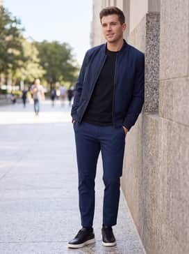 Mens Grand Crosscourt Daily Court Sneakers – Tapered navy blue trousers worn with a high-quality black pima cotton t-shirt and a sleek navy bomber jacket for a refined streetwear look.