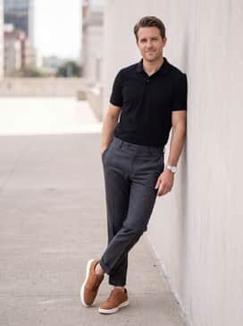 Mens Grand Crosscourt Modern Tennis Sneakers – Tailored charcoal grey trousers worn with a black piqué polo shirt and no-show socks to highlight the sneaker's sleek silhouette.
