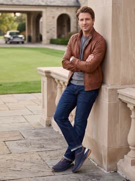 Dark wash indigo jeans paired with a grey crewneck cashmere sweater and a brown leather jacket to complement the shoe's accents.