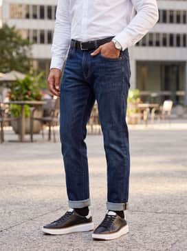 Indigo raw denim jeans, a crisp white button-down shirt tucked in, and a black leather belt to mirror the shoes' premium finish.