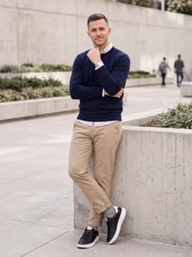 Tapered khaki chinos paired with a navy blue lightweight merino wool sweater for a classic, preppy weekend ensemble.